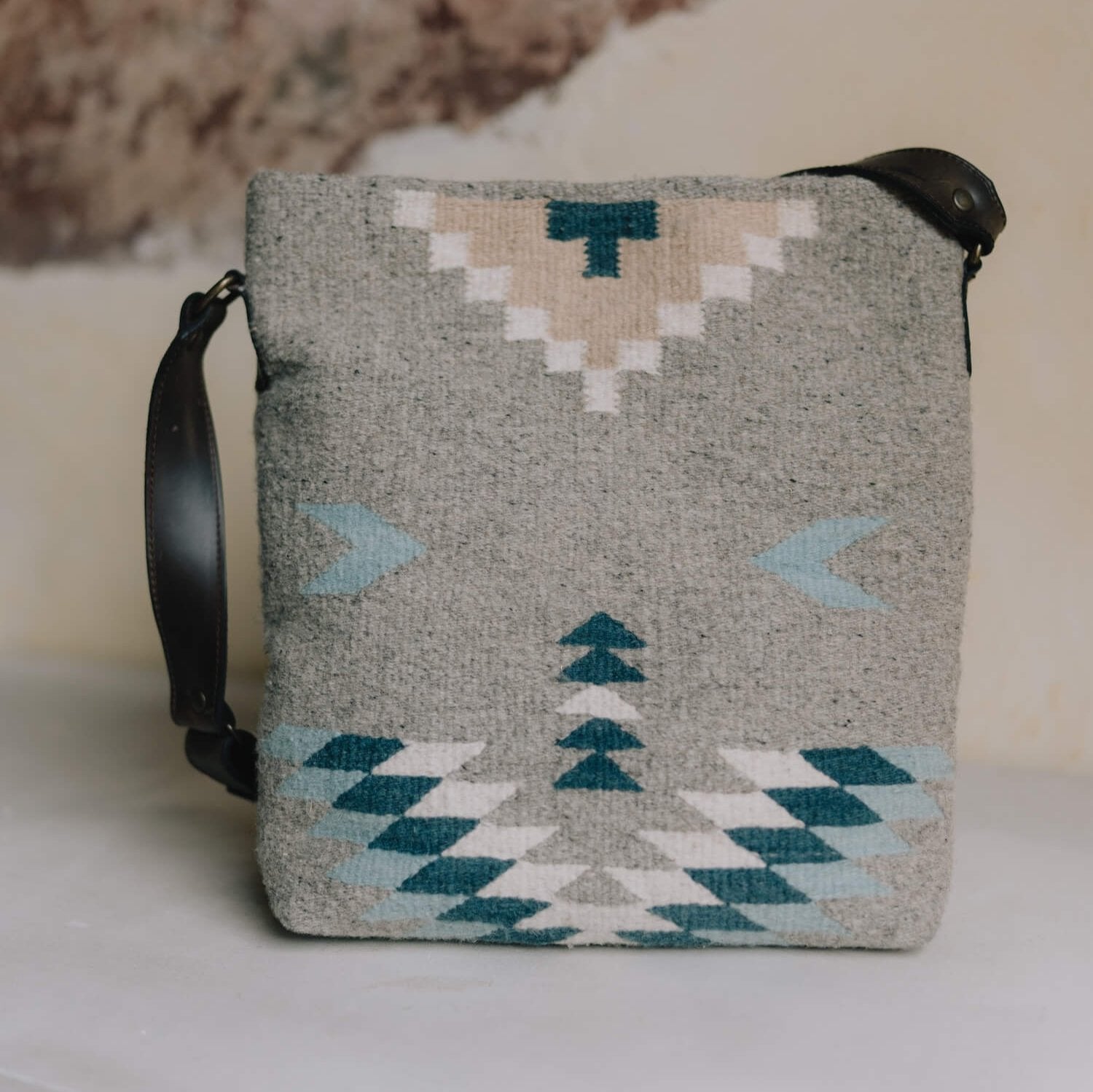 AMASOUK handwoven wool Aguila Shoulder/Crossbody bag featuring a Zapotec pattern in blue, ivory, and honey on a gray backdrop. Stylish and versatile for daily use and evening outings.