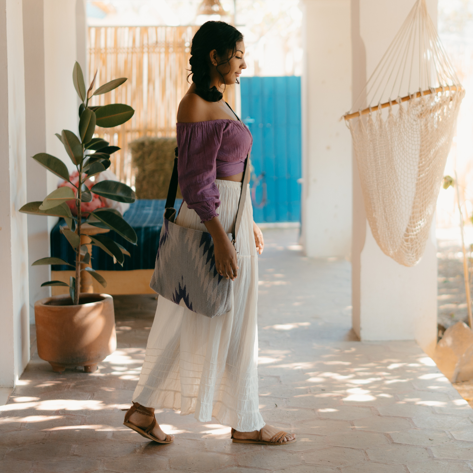 Woman carrying an AMASOUK handwoven wool Amethyst shoulder/crossbody bag, featuring shades of purple. Perfect for errands, work, or casual outings.