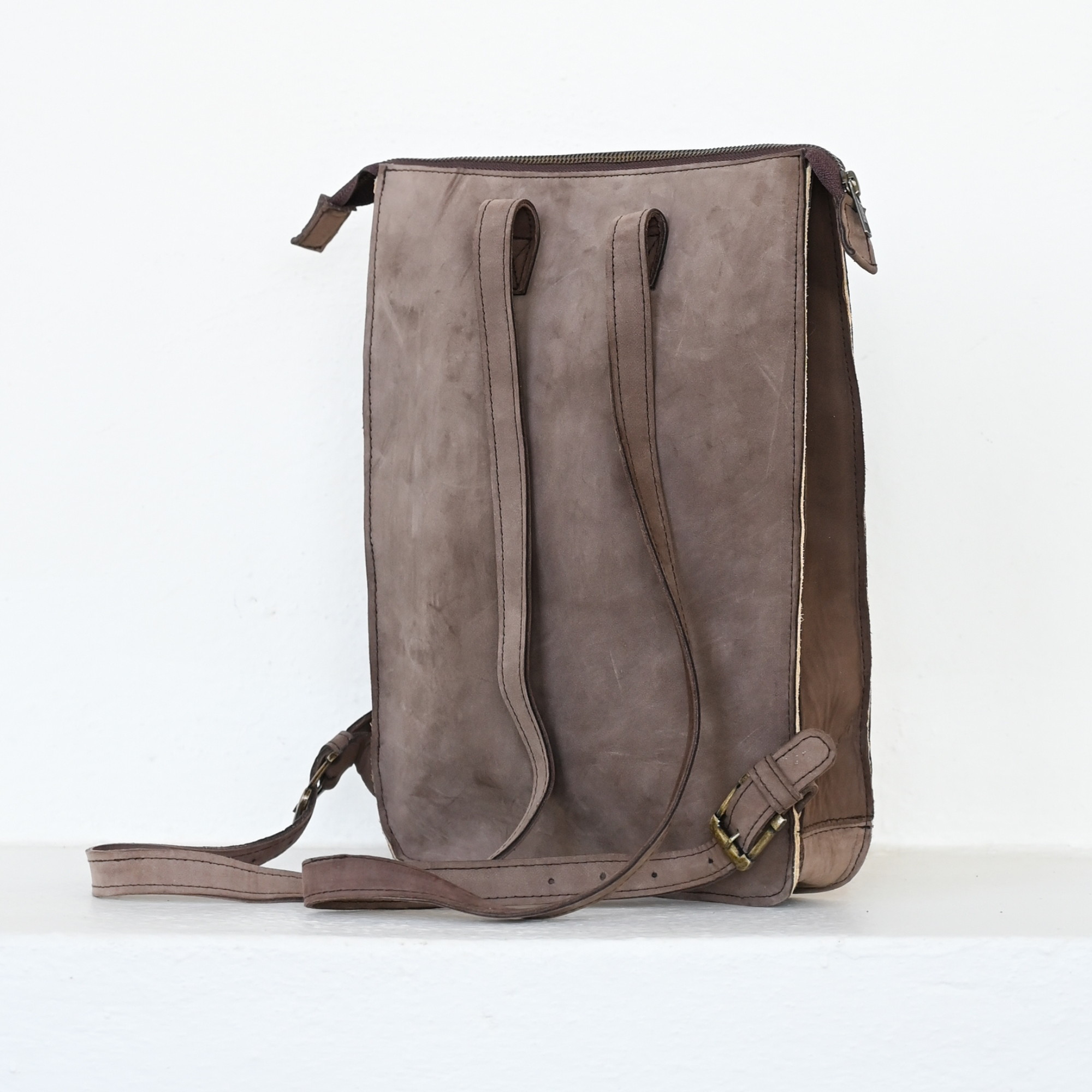 Back view of AMASOUK Mora Slim Backpack, crafted from dark brown leather and wool in cream and rosy hues. Perfect for daily errands or a casual day out. Zapotec pattern.
