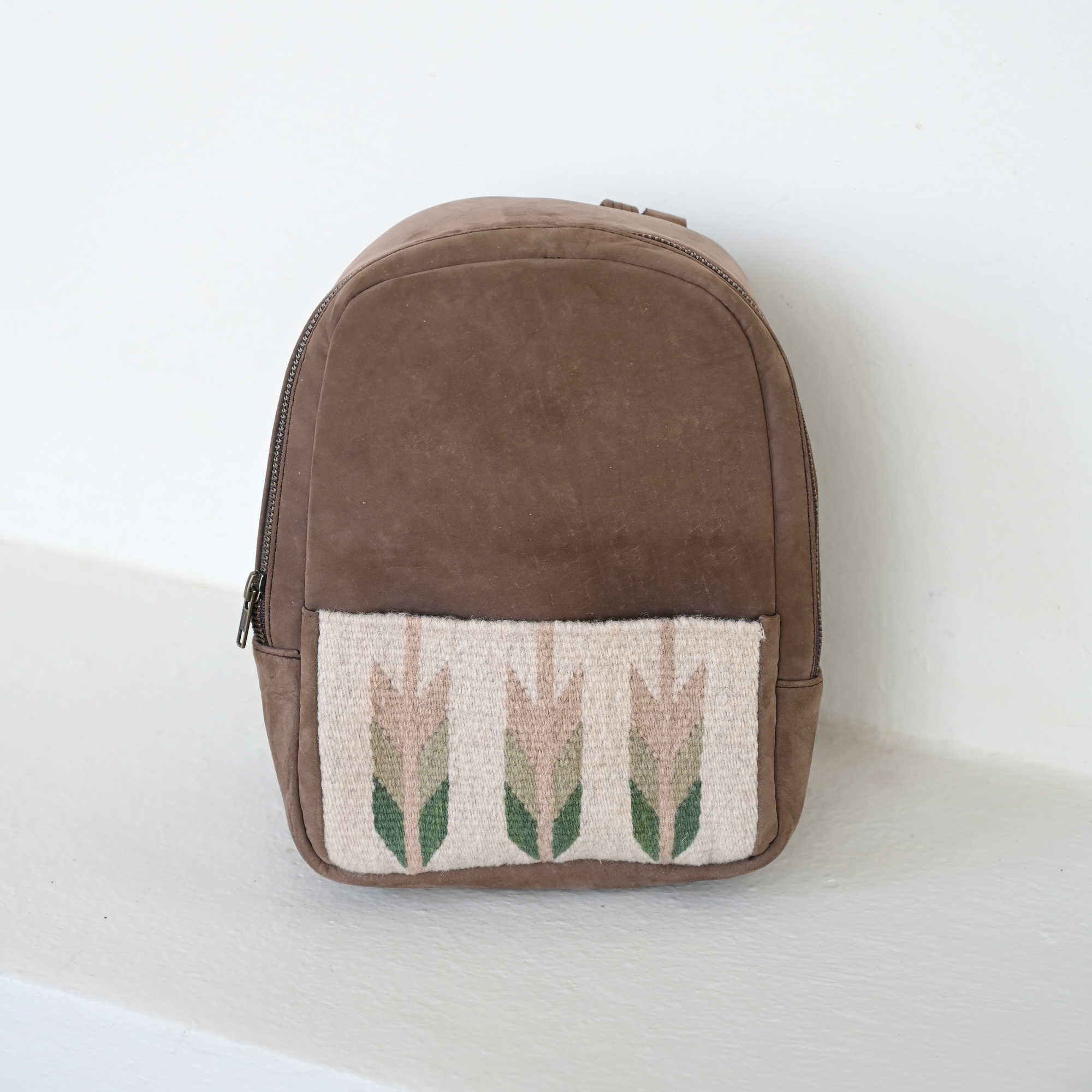 Elegant AMASOUK Arbol Mini Backpack crafted from leather and wool, showcasing brown leather with light green and cream wool. Perfect for a day out or as a compact carry-all.