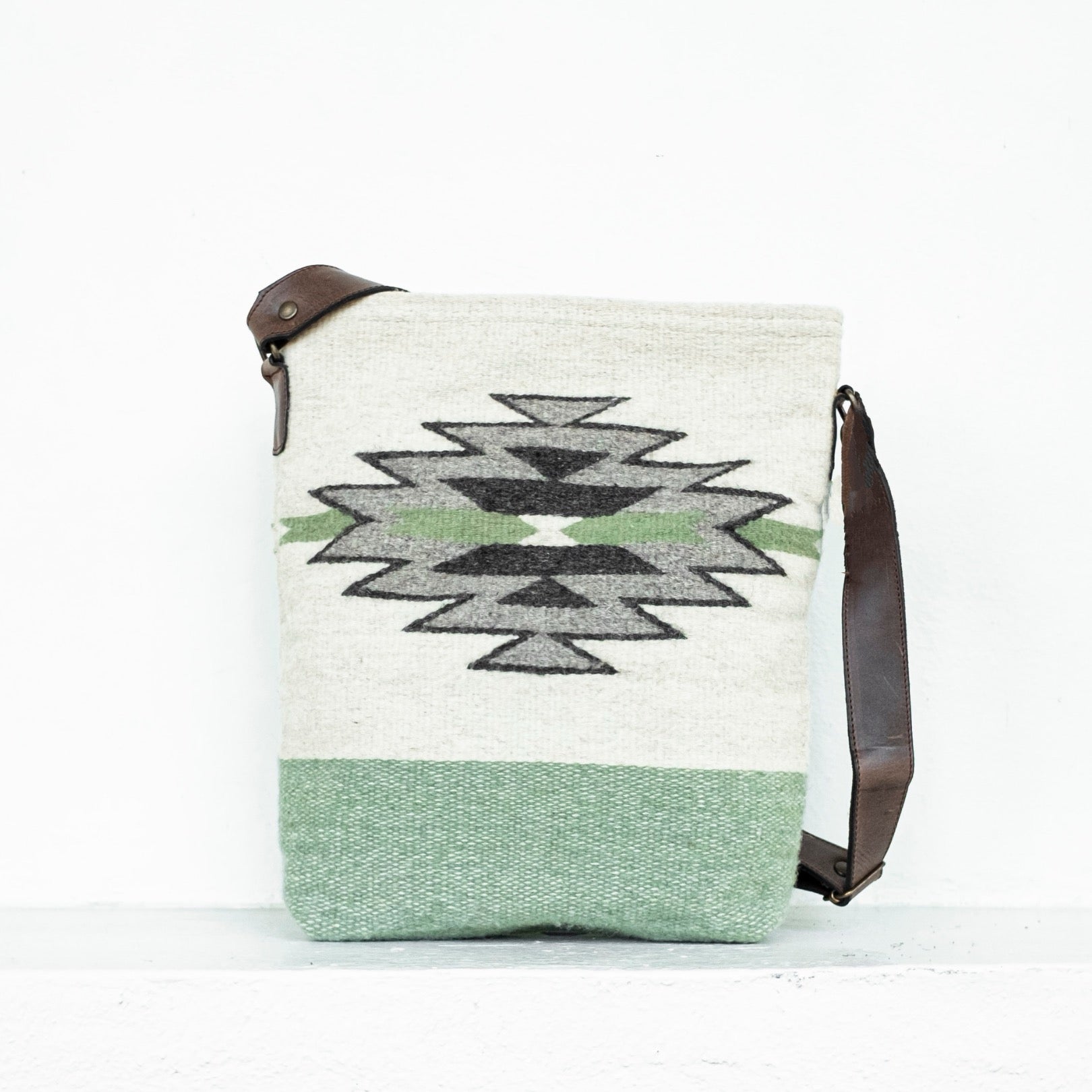 AMASOUK roomy handwoven wool and leather Sendero convertible shoulder/crossbody bag with a sophisticated combination of pale green, creamy white, and light gray. Ideal for any day-to-night occasion.