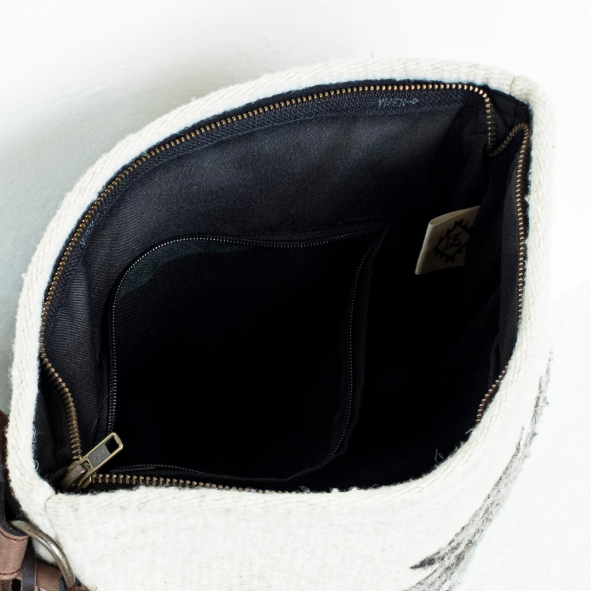 Interior view of AMASOUK handwoven wool and leather Sendero convertible shoulder/crossbody bag in a harmonious mix of gentle green, ivory, and soft gray. Effortlessly stylish for day-to-night use.