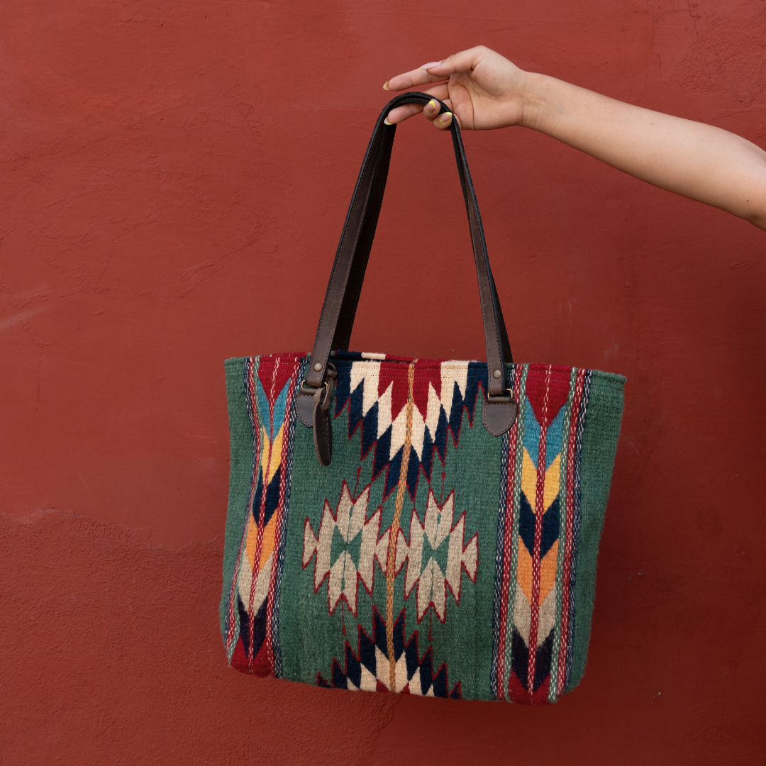 Handwoven wool tote bag in green and bold colors with Zapotec patterns, leather shoulder straps, and relaxed shape, roomy and ideal for everyday use.