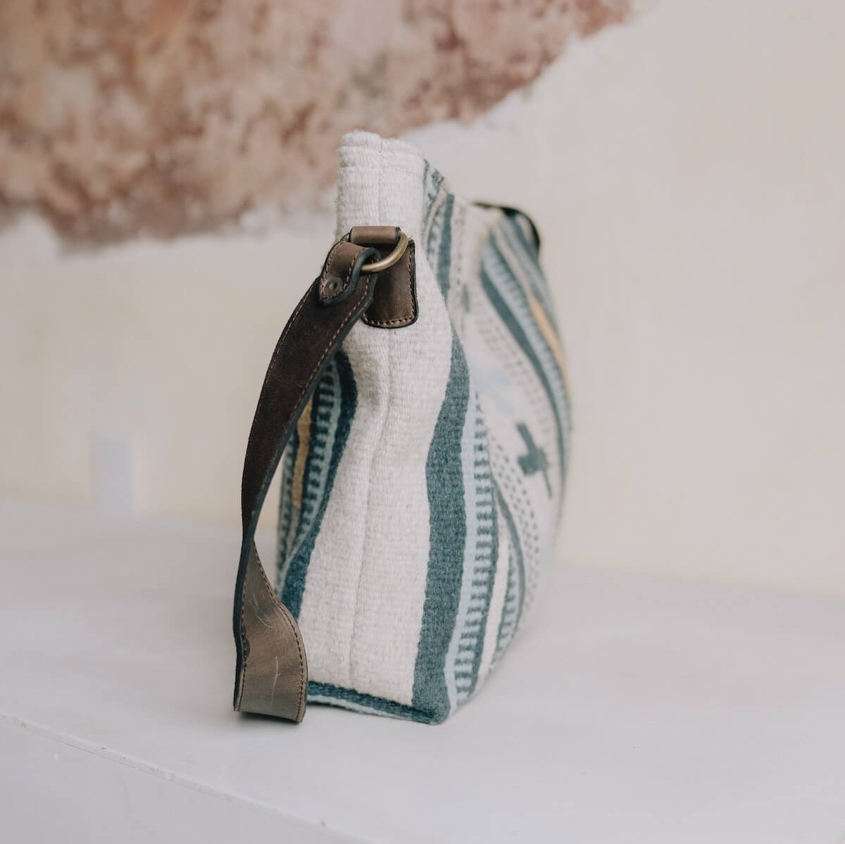 Elegant AMASOUK Copalita handwoven wool and leather convertible shoulder/crossbody bag in blue, cream, honey, and gray. The perfect blend of functionality and fashion.