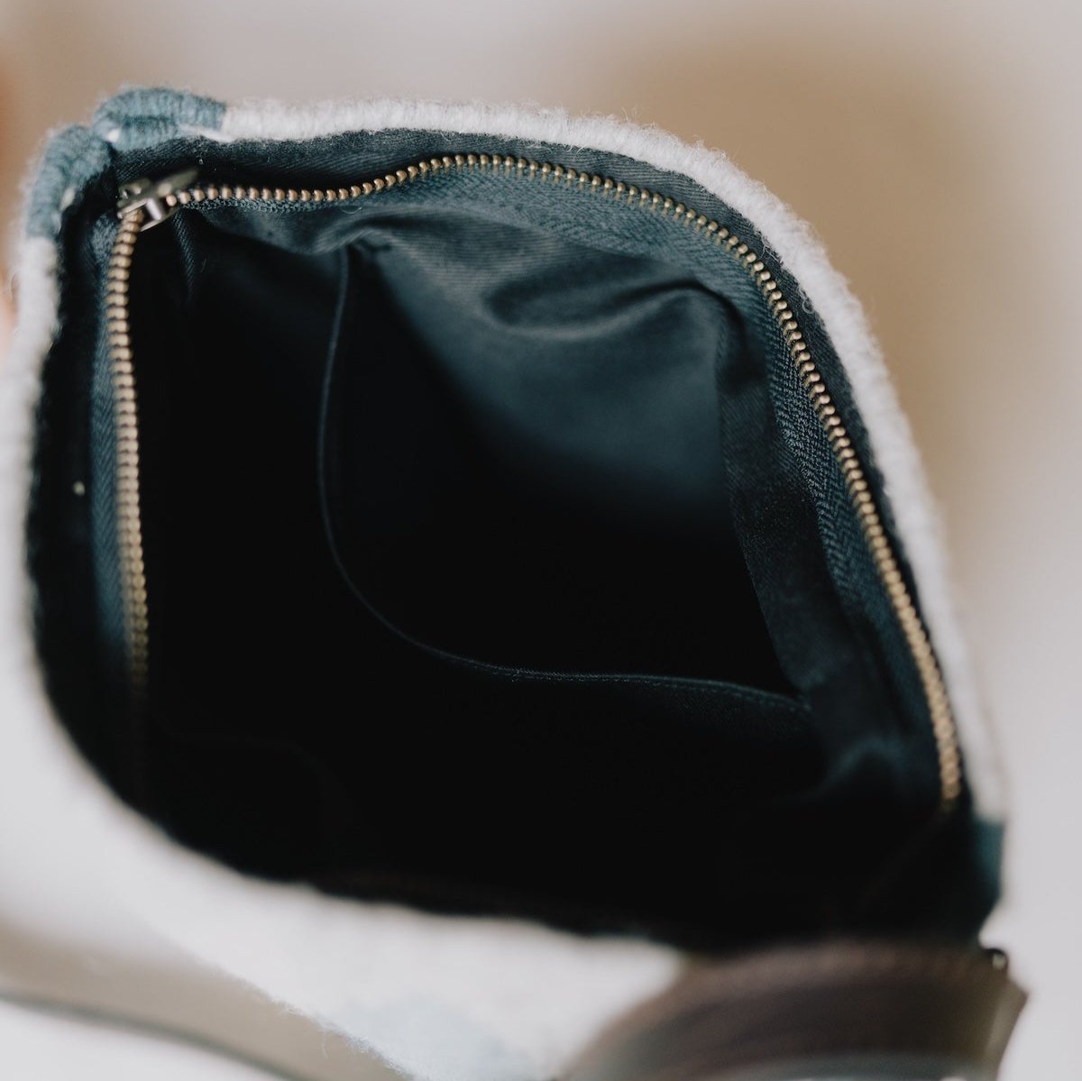 Interior view of AMASOUK Espejos Crossbody bag with dark brown leather strap, handwoven wool in blue, heather gray, and ivory, adorned with intricate Zapotec patterns. Stylish and crafted by artisans.