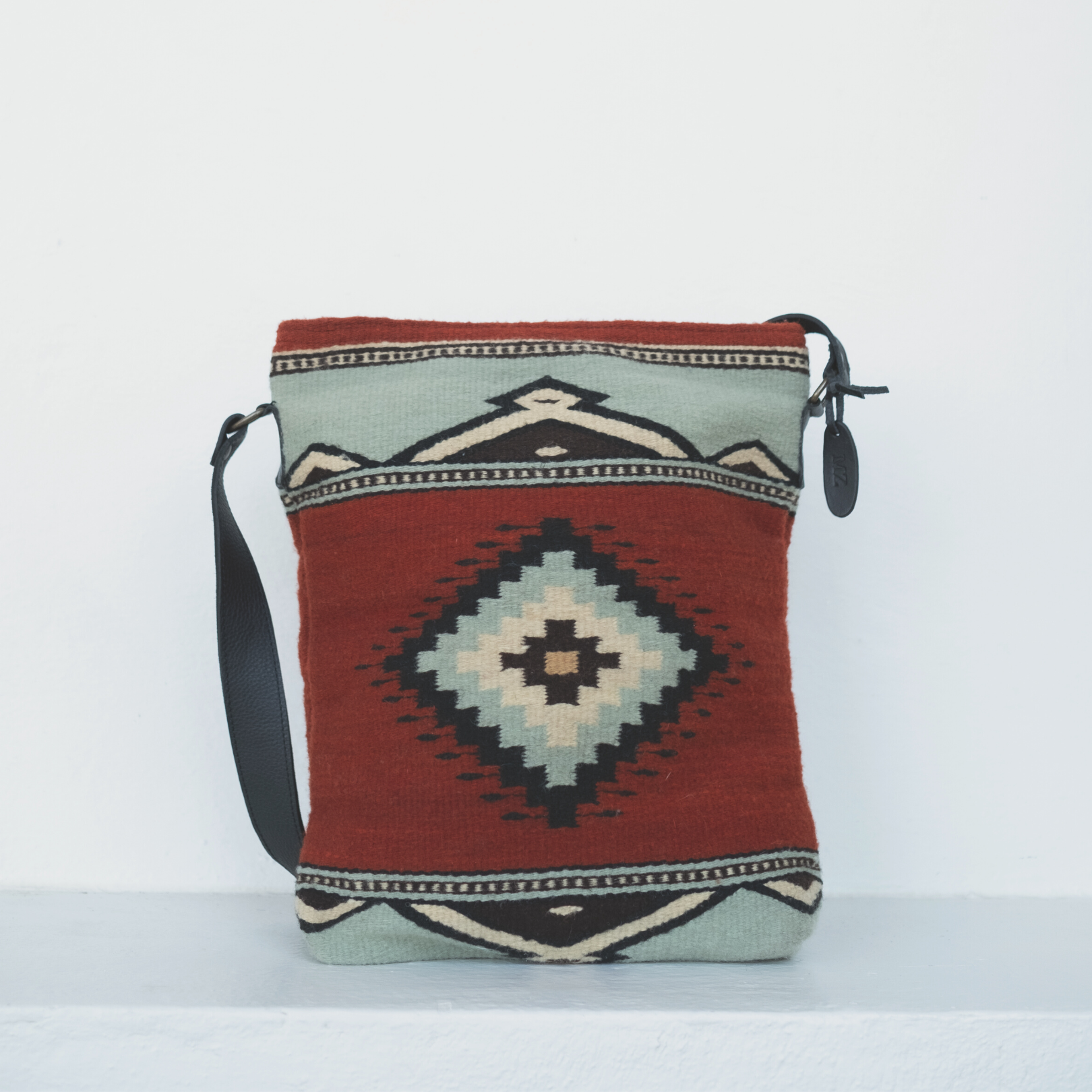 AMASOUK handwoven wool convertible shoulder/crossbody bag with Adobe + Azul name, featuring a Zapotec pattern in rich adobe red and soft mint green. Stylish and versatile for daily use and evening outings.