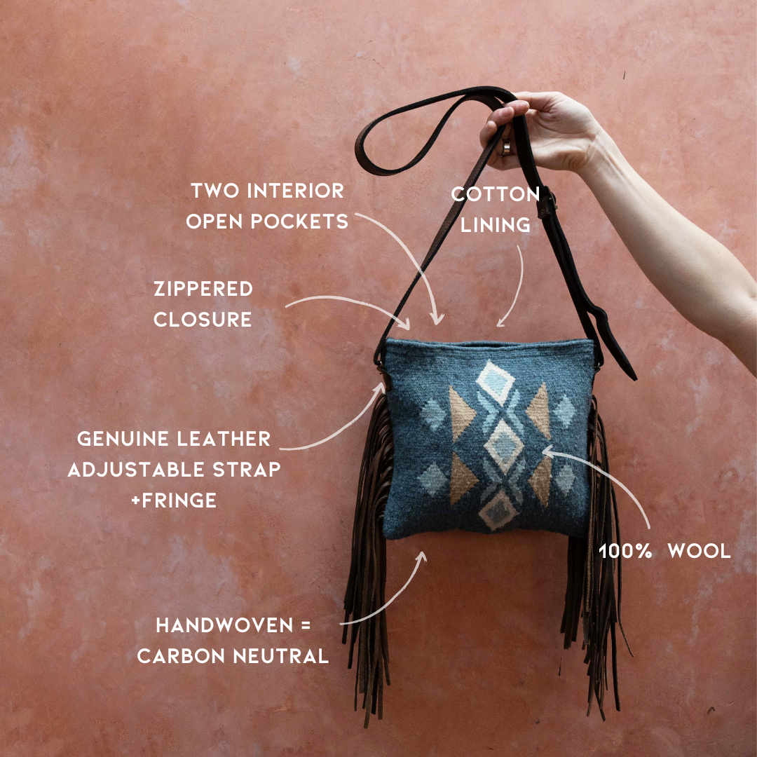 Festive AMASOUK Jalisco Fringe Crossbody featuring a dark brown leather strap, side fringe, and handwoven wool in blue, heather gray, and honey. Embellished with traditional Zapotec patterns.