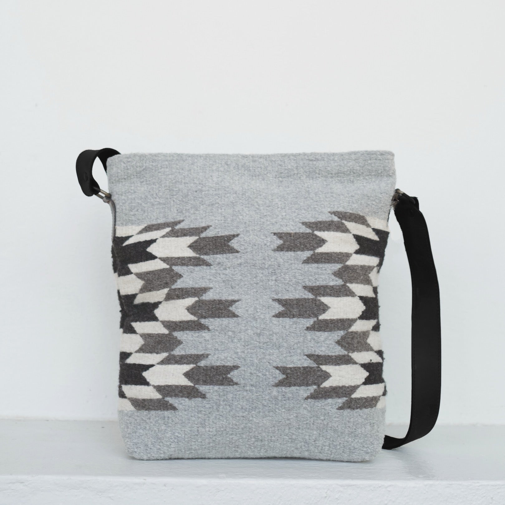 AMASOUK handwoven wool convertible shoulder/crossbody bag with Leona name, featuring a Zapotec pattern in natural tones of charcoal, ivory, and stone. Sophisticated and versatile for daily use and evening outings.